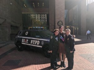 Detective Frances O’Hanlon, Lunx Girgado and Deputy Chief Kathleen White standing in front of an NYPD car.