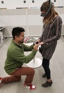 Thomas Chan proposing to Carly Wade on one knee.
