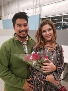 Thomas Chan poses with Carly Wade, who is holding a bouquet of roses.