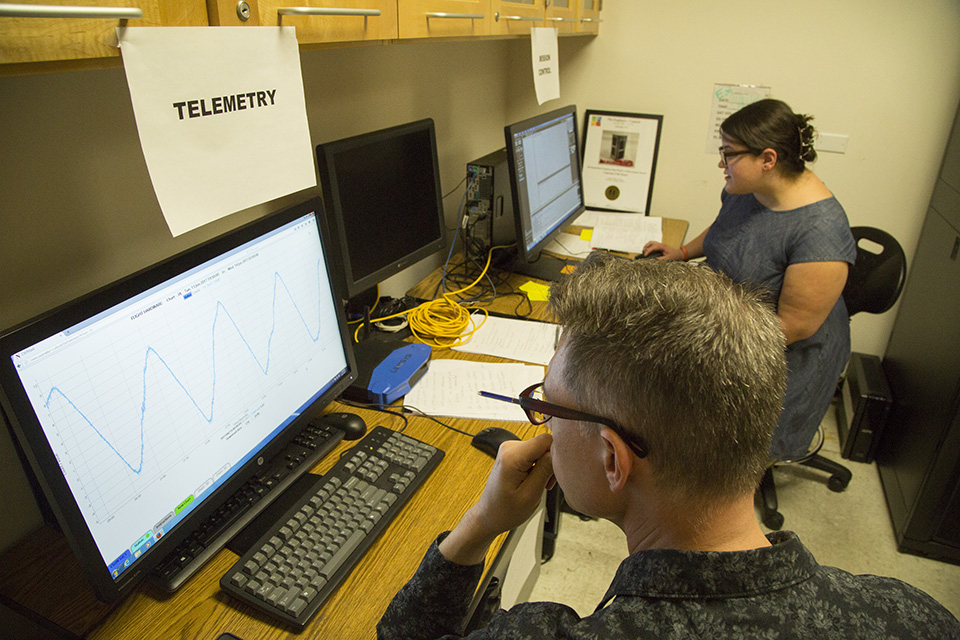 CSUNSat1 alumnus Benjamin Plotkin '16 and electrical engineering graduate student Rosy Davis run the telemetry and mission control stations as they monitor the CubeSat's pass over Northridge, on June 14, 2017. Photo by Richard Chambers.