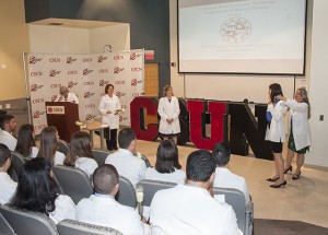A new DPT student receives her white coat, symbolizing the beginning of her doctoral path, August 2016. Photo by Luis Garcia. 