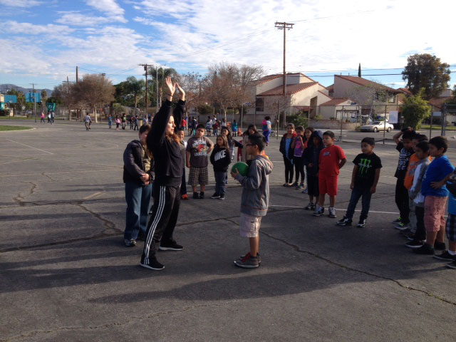 A CSUN kinesiology undergraduate works on basketball skills with students at Hart Street Elementary School in Canoga Park. Photo courtesy of Terry Sweeting.
