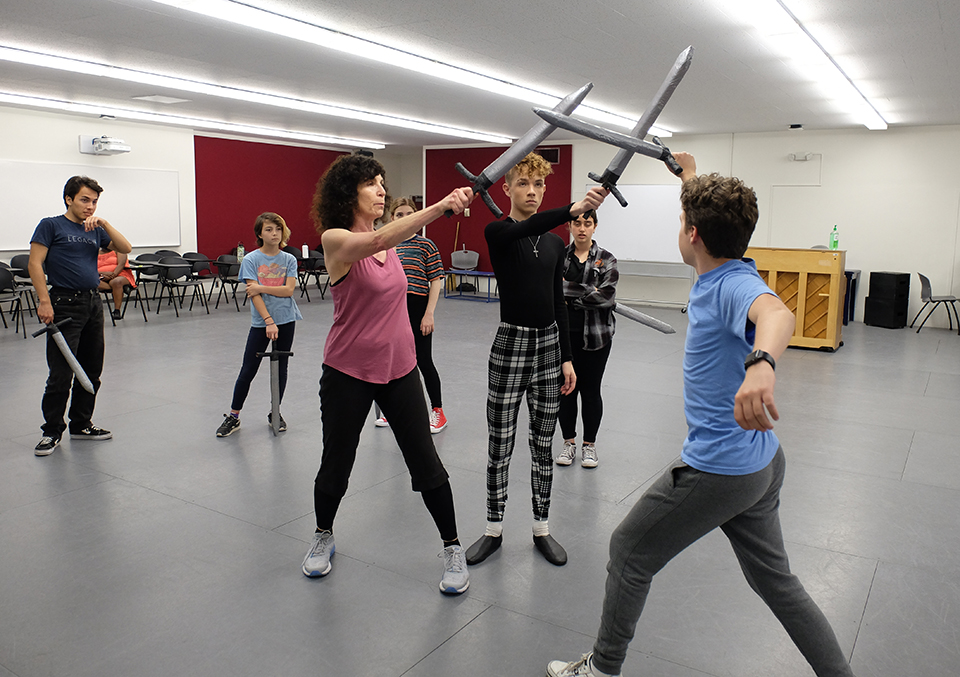 Rehearsing a fight scene for 'Jason and the Argonauts' are, from left, Bret Barrera, Nora Yi, Heidi Noro, Kylie Hamuel, Sebastian Schlesinger and Adam Jacobson with assistance from assistant director and choreographer Candy Sherwin (center, in the red shirt). Photo courtesy of Teenage Drama Workshop.