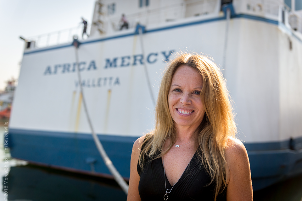 CSUN Communications Studies Professor, Michele Mega standing in front of Africa Mercy.