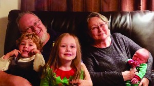 Family photo of Richard and Cheryl McMillan with their three grandchildren.