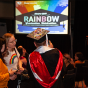 A graduating student's cap, covered in glitter and images about trans rights, shines under the rainbow-colored lights at the Rainbow Graduation Celebration on May 17.