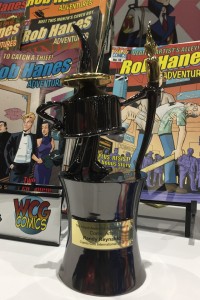 Randy Reynaldo's Inkpot Award on display with issues of Rob Hanes Adventures.
