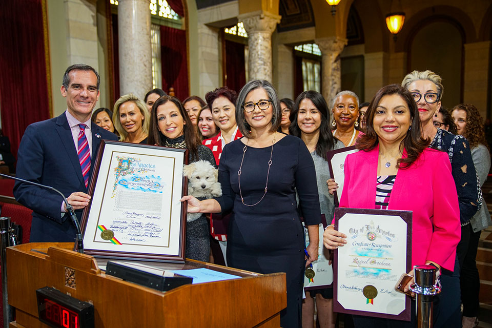 Raquel Orochena (right, in pink jacket) is honored at City Hall along with several other women by Mayor Eric Garcetti (far left) on Dec. 13, 2017, for Women's Entrepreneurship Day in Los Angeles. Photo courtesy of Mayor's Office.