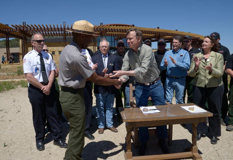 Colorado Gov. John Hickenlooper presents a ceremonial pen to Mesa Verde National Park Superintendent and CSUN alumnus Cliff Spencer after the governor signed a wildfire funding bill at the park in June 2013.