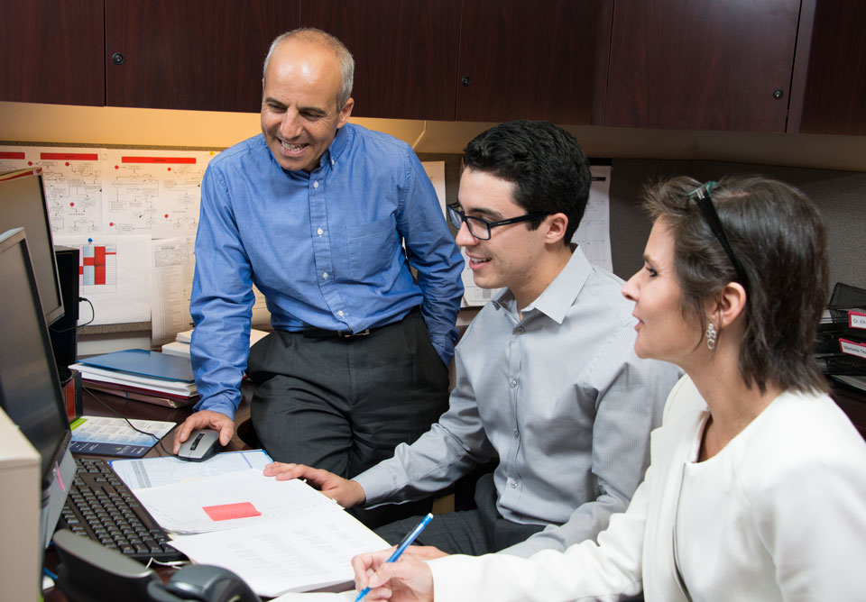 Professor Rafi Efrat (left) works with students in CSUN's David Nazarian College of Business and Economics on federal tax procedures. Photo by Lee Choo.