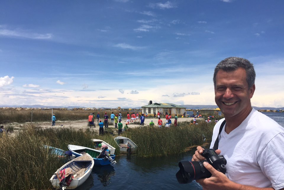 CSUN professor Chris Bolsmann holds a camera by Lake Titicaca as he watches a soccer match in Peru.