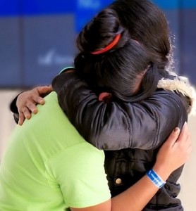 A woman in a coat hugs her 16-year-old daughter tight after a two-month separation while in the custody of the U.S. federal government.