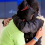 A woman in a coat hugs her 16-year-old daughter tight after a two-month separation while in the custody of the U.S. federal government.