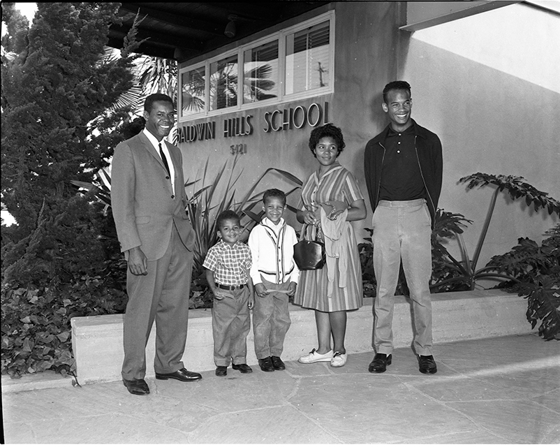 Mr. and Mrs. James Garr stand with their children, Todd and Randy, in front of Baldwin Hills Elementary School.