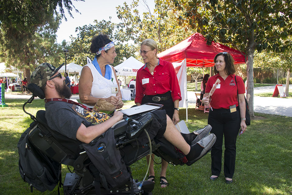 CSUN President Dianne F. Harrison greets student in wheelchair.