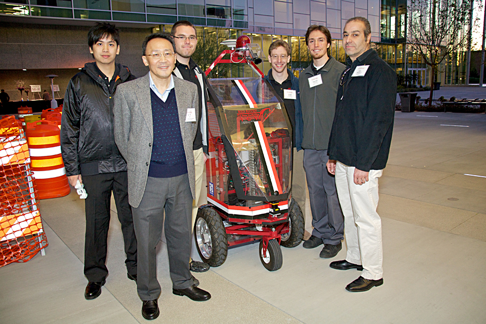 A professor and his students with their robot 