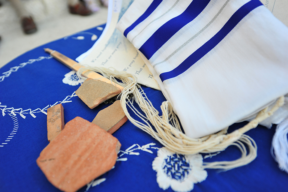 Ancient pottery pieces from Israel rest on a Jewish prayer shawl.