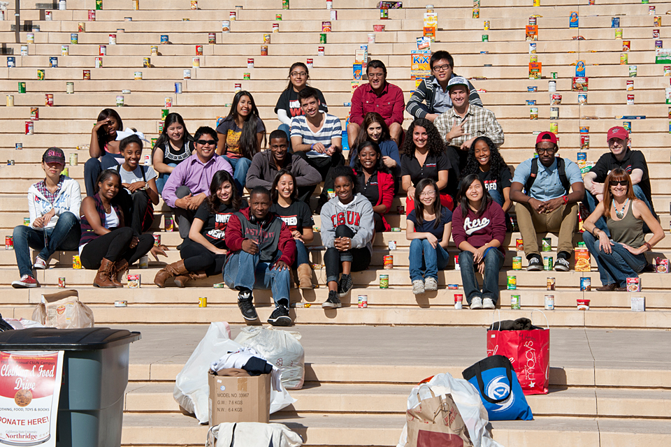 Members of Unified We Serve, the campus’ volunteer program, display items collected during the fourth annual clothing and food drive on the steps of the Delmar T. Oviatt Library.