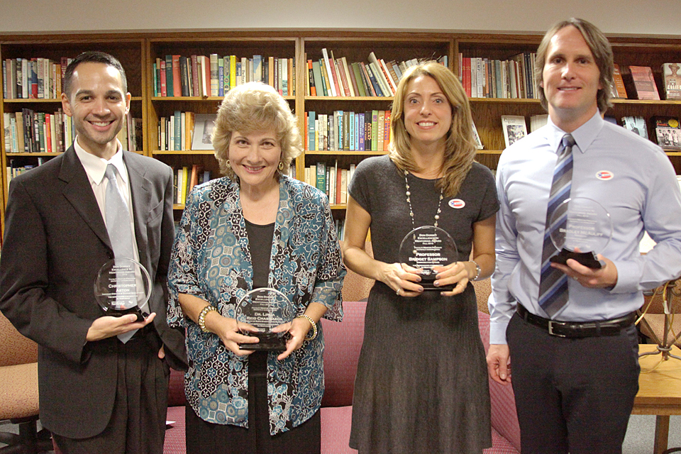 The winners of the 2012 Don Dorsey Excellence in Mentoring Award standing in an office (from left): Christopher Aston ’02 (Communication Studies), M.A. ’04 (Communication Studies), assistant director of student development and international programs; Dr. Yolanda Linda Reid-Chassiakos, director of the Klotz Student Health Center; Bridget Sampson ’91 (Speech Communication), M.A. ’93 (Speech Communication), professor of communication studies; and Bradley McAuliff, professor of psychology.