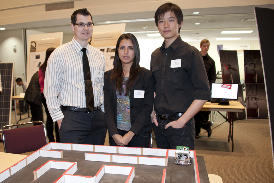 Jeff Bouchard, Karla Ananias, and Qian Wang with their micromouse in a maze