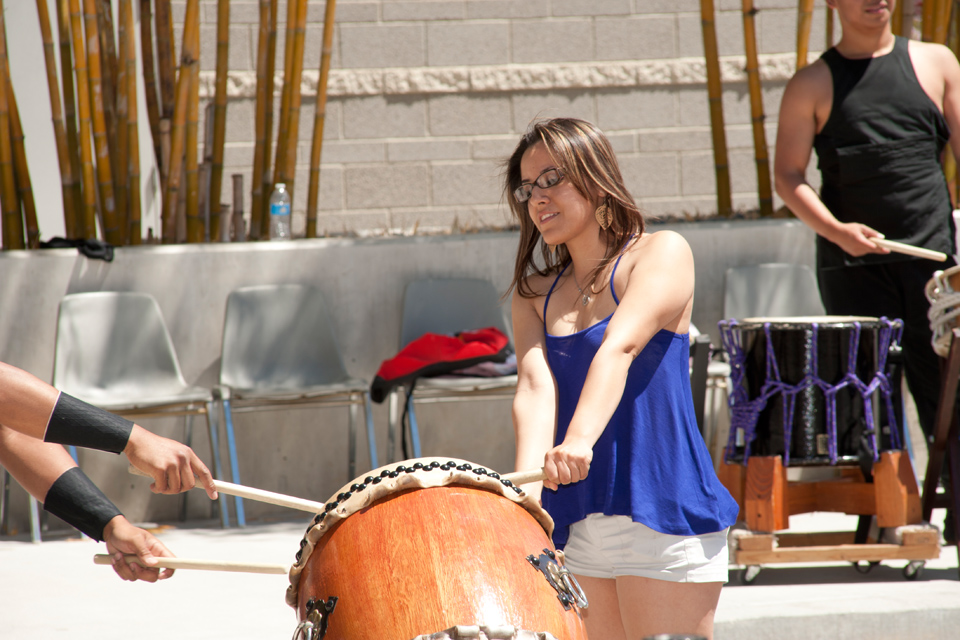 A female student trying to play a taiko drum.