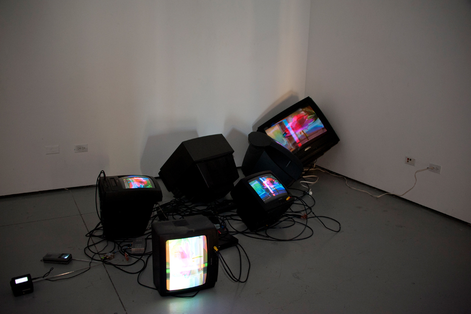A group of televisions in various positions on the floor playing videos