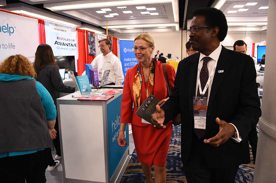 CSUN President Dianne F. Harrison and Vice President of Student Affairs and Dean of Students William Watkins walk the CSUN Conference exhibit hall.