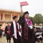Student holds up diploma after graduating.