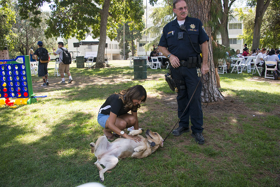 Student rubs CSUN Department of Police Services K9.