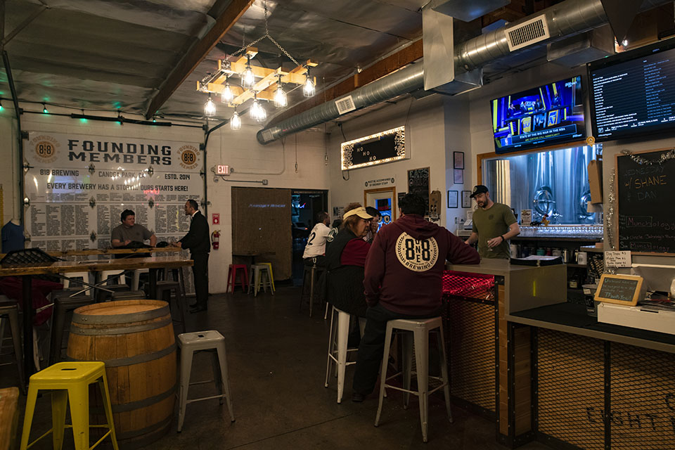 Patrons sit on stools in the 8one8 Brewing tasting room in Canoga Park.