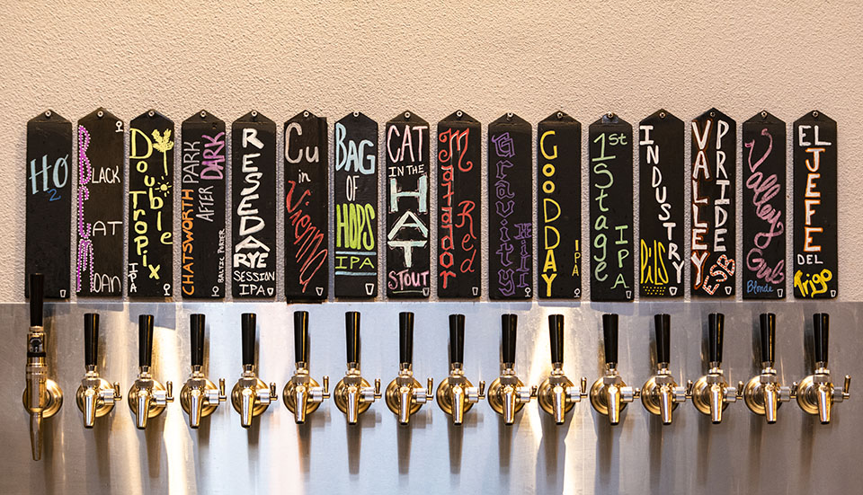 A wall of beer taps displays 8one8 Brewing beer names such as Valley Girl Blonde, Matador Red and Reseda Rye.