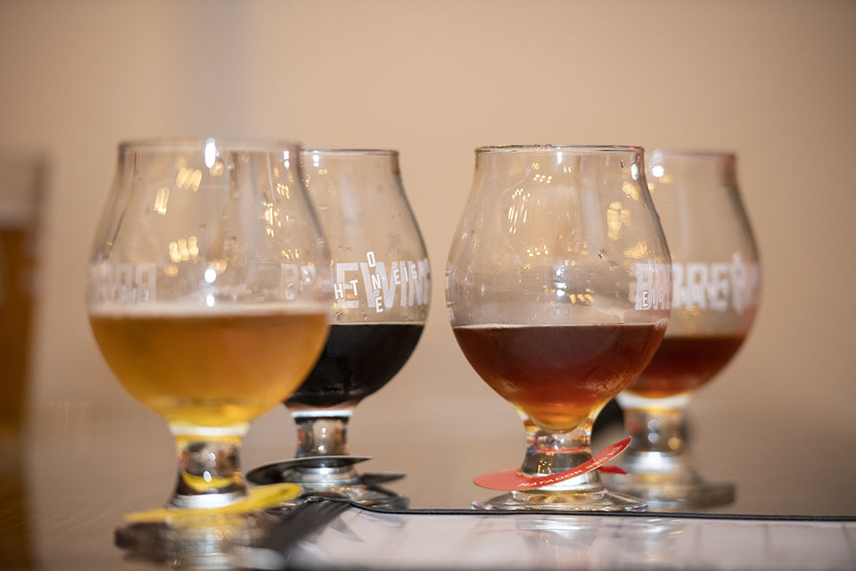 Four tasting glasses with a flight of 8one8 beer sit on the bar in the taproom.