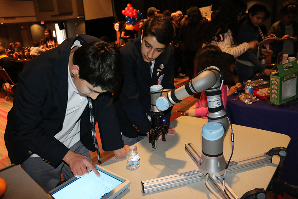 Students work with robotic arm