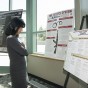 Woman stands studying poster
