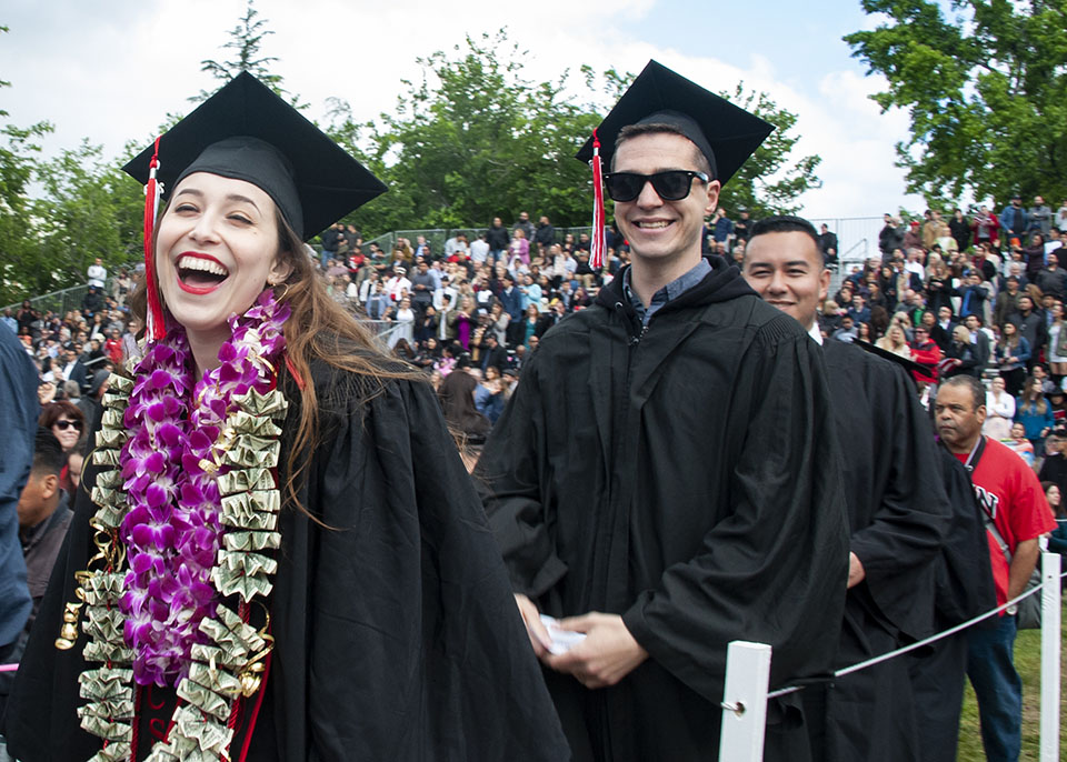 Joyous graduates file onto the Oviatt Lawn at CSUN commencement.
