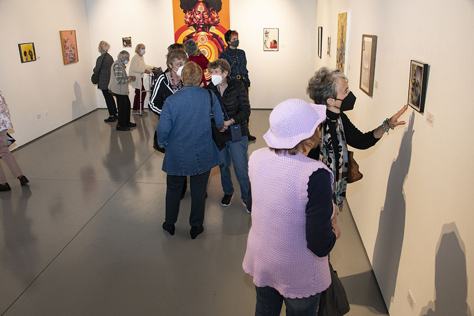 People wearing masks admire artwork displayed on CSUN West Gallery walls