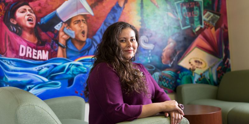 CSUN Special Assistant to the President for Inclusive Excellence Amanda Quintero in front of a colorful mural.