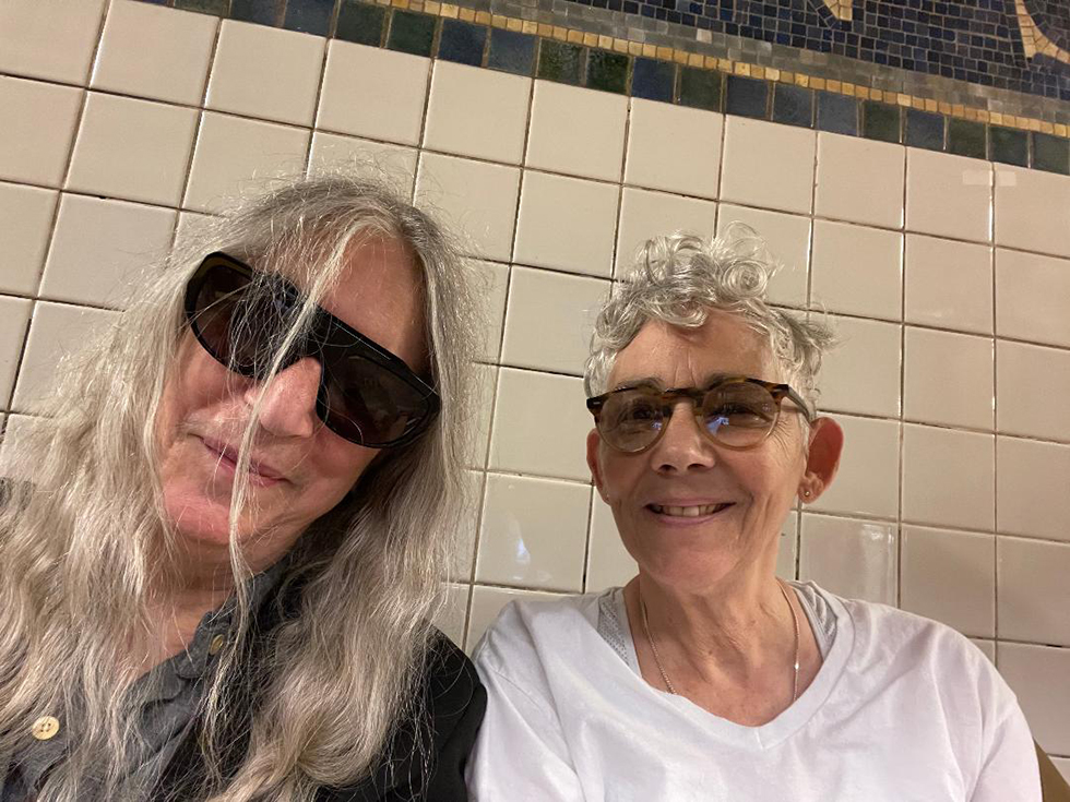 Patti Smith and Andi Ostrowe sitting together on the subway train.