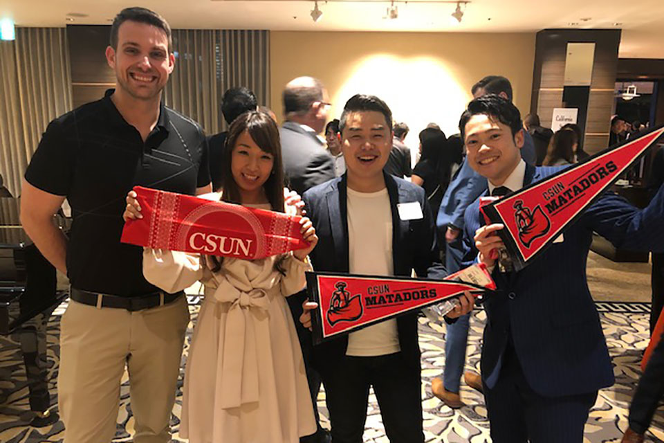 Matadors hold CSUN pennants at the California State University Alumni Reception in Tokyo on March 1.