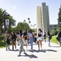 Students walk on sidewalk with Sierra Clock Tower in the background.