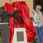 Provost Mary Beth Walker and a Nazarian College business student lift a red drape off of the Beta Gamma Sigma 