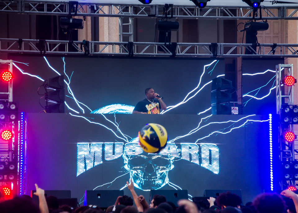 DJ Mustard performing on stage.