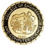 A gold "Challenge Coin" for the College of Engineering and Computer Science features an image of CSUN's Jacaranda Hall.
