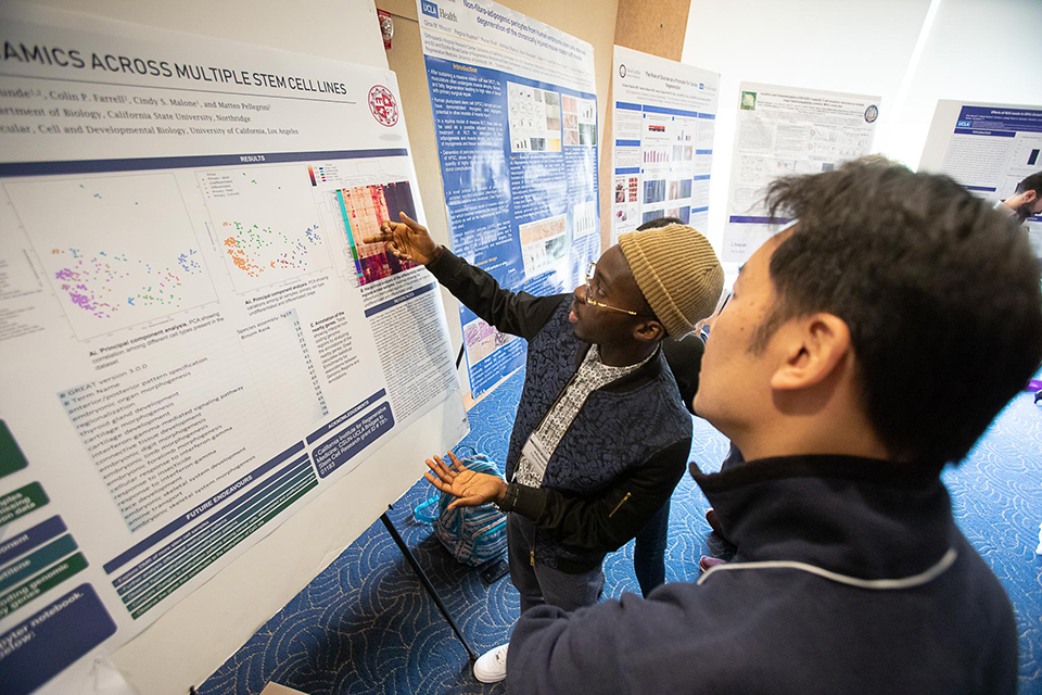 Ahmed Oyetunde (left), a former CSUN-UCLA intern in the lab of UCLA’s Matteo Pellegrini, presents his research project at the UCLA Broad Stem Cell Research Center’s 15th annual Stem Cell Symposium. | Credit: Reed Hutchinson, UCLA Broad Stem Cell Research Center 