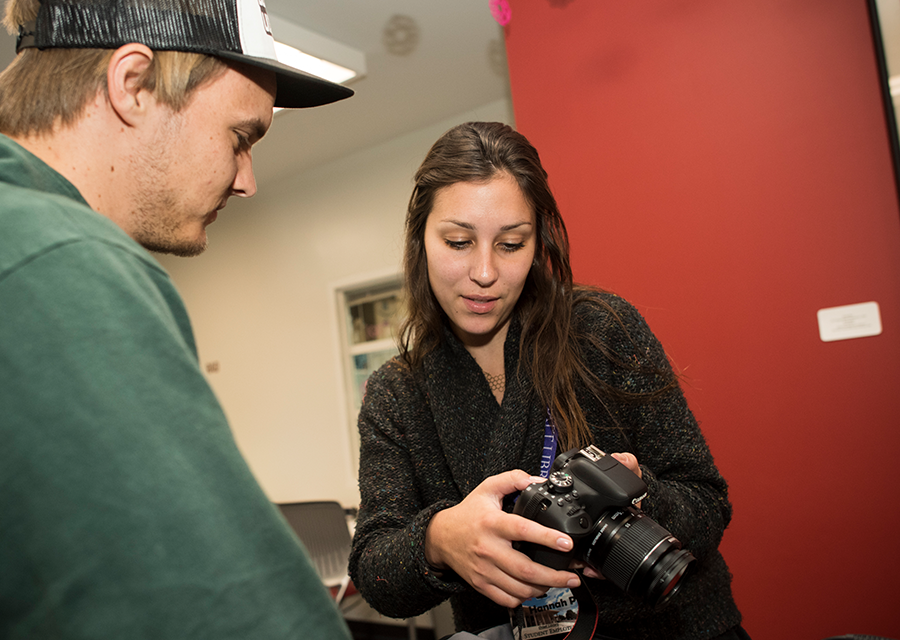 A student demonstrates the functions of a DSLR camera at the Creative Media Studio.