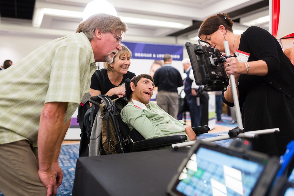 Man using wheelchair and caregivers look at assistive technology