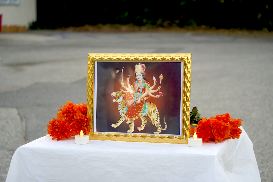 A framed photo of the Goddess Durga sits upon a table at the event.