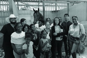 Group pictures of the Compton Junior Equestrians, pictured in front of a horse in his stall.