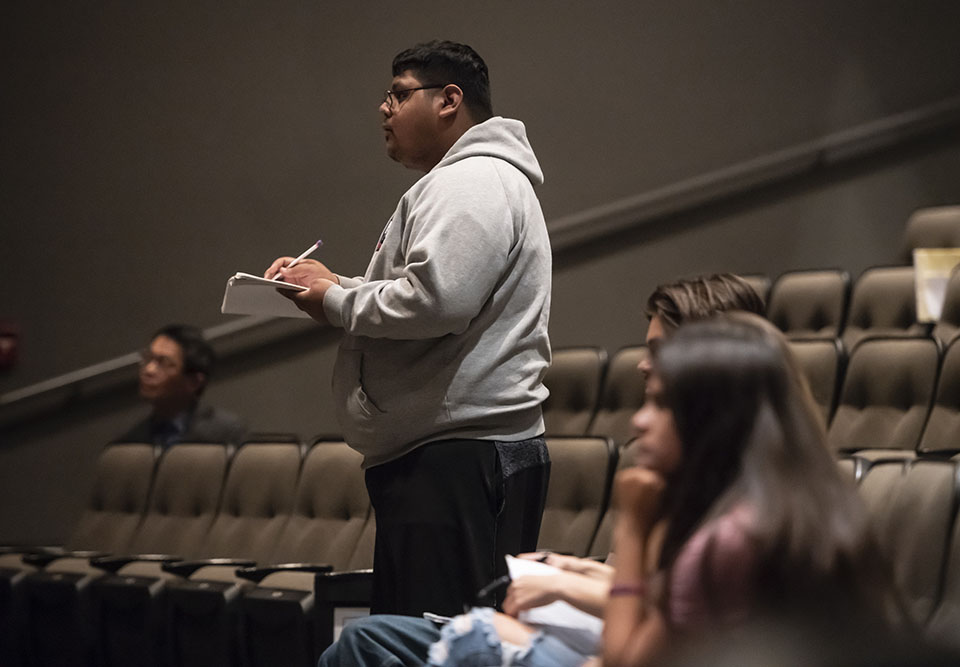 A CSUN student stands in the Plaza del Sol Performance Hall audience, asking a question of the Court of Appeal justices.