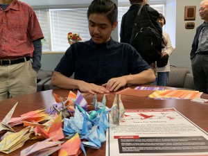 Student Jason Quan folding an origami crane, a "Tsuru," during a "Tsuru for Solidarity" event hosted by Civil Discourse and Social Change. Photo courtesy of Jinah Kim.